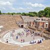 "Pompeii, Italy - July 24, 2012. Tourists mill about and sit and relax inside of the ancient Pompeii Amphitheatre. Pompeii was victim to the 79 A.D. eruption of Mount Vesuvius."
